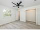 This bedroom features light, neutral walls, light wood-look floors and ceiling fan and closet at 1008 Shangri La Dr, Seffner, FL 33584