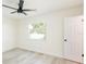 This bedroom features light, neutral walls, light wood-look floors and ceiling fan at 1008 Shangri La Dr, Seffner, FL 33584