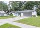 View of a well maintained home with a two car garage and a well manicured lawn at 1008 Shangri La Dr, Seffner, FL 33584