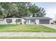Charming single-story home with a painted brick facade, lush landscaping, and inviting curb appeal at 1008 Shangri La Dr, Seffner, FL 33584