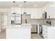 Modern kitchen featuring white cabinets, stainless steel appliances, quartz counters and tiled backsplash at 1008 Shangri La Dr, Seffner, FL 33584