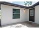 Exterior view of patio with stucco wall, window and doorway with decorative glass at 1008 Shangri La Dr, Seffner, FL 33584
