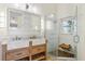 Bright bathroom features a double sink vanity, custom wood cabinet, and glass shower at 10304 Rainbow Oaks Dr, Hudson, FL 34667