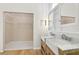 Bright bathroom with double sink vanity, wooden cabinet, glass shower, and a walk-in closet at 10304 Rainbow Oaks Dr, Hudson, FL 34667
