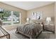 This staged bedroom features light-colored walls, a large window with natural light, and stylish contemporary decor at 10304 Rainbow Oaks Dr, Hudson, FL 34667