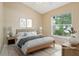 This staged bedroom features light-colored walls, a large window with natural light, and stylish contemporary decor at 10304 Rainbow Oaks Dr, Hudson, FL 34667