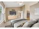 Staged bedroom featuring a TV, closet, and open access to another room at 10304 Rainbow Oaks Dr, Hudson, FL 34667