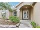 Close-up of the front entrance with decorative glass door, plants and a stone-lined flowerbed at 10304 Rainbow Oaks Dr, Hudson, FL 34667
