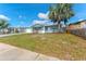 Charming home with a well-maintained lawn, an attached garage, and a welcoming front entrance at 1051 Pert Ln, Holiday, FL 34691