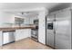 The kitchen features white cabinets, stainless steel appliances, and stylish tile backsplash at 1051 Pert Ln, Holiday, FL 34691