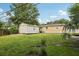 Spacious backyard with a detached shed, lush greenery, and mature trees at 109 Emerald Ln, Largo, FL 33771