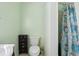 Simple bathroom featuring a toilet, small cabinet, and shower with a patterned curtain at 109 Emerald Ln, Largo, FL 33771