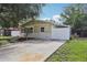 Well-maintained home with a concrete driveway, American flag, palm tree, and manicured lawn at 109 Emerald Ln, Largo, FL 33771