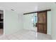 Tile-floored hallway with sliding barn doors provides access to laundry room and kitchen at 109 Emerald Ln, Largo, FL 33771