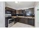 Well-appointed kitchen with dark cabinetry, stainless steel appliances, and tile backsplash at 109 Emerald Ln, Largo, FL 33771