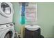 Laundry room featuring a stackable washer and dryer, vanity, sink, mirror and window at 109 Emerald Ln, Largo, FL 33771