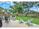 Spacious backyard featuring a wood deck with chairs, lush green grass, and a privacy fence at 111 E Jean St, Tampa, FL 33604