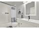 Well-lit bathroom boasts a tub-shower combo with a grey and white curtain, a vanity, and an Eiffel Tower picture at 111 E Jean St, Tampa, FL 33604