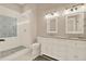 Bright bathroom features a glass shower with decorative tile and a double vanity with granite countertop at 111 E Jean St, Tampa, FL 33604