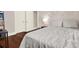 Bedroom featuring a cozy atmosphere, with floral wall decor, hardwood flooring, and a comfortable patterned bedspread at 111 E Jean St, Tampa, FL 33604