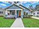 Charming blue home featuring a well-manicured lawn and inviting front porch with columns at 111 E Jean St, Tampa, FL 33604