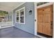 Close up of the cozy front porch with white swing, and a wooden front door at 111 E Jean St, Tampa, FL 33604