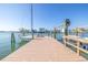 View of the boat dock with a sailboat and a lift, with a waterfront neighborhood in the background at 11160 8Th E St, Treasure Island, FL 33706