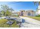 Well-maintained home exterior with lush landscaping and circular driveway at 11160 8Th E St, Treasure Island, FL 33706