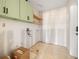 Unfinished laundry room featuring sage green cabinets and natural wood shelving at 11160 8Th E St, Treasure Island, FL 33706
