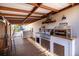 Covered outdoor kitchen with stainless steel grill and dining space at 11160 8Th E St, Treasure Island, FL 33706
