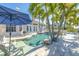 Inviting pool with lounge chairs, palm trees, and french doors offering a serene outdoor retreat at 11160 8Th E St, Treasure Island, FL 33706