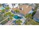 Aerial view of a home with a pool, spa, and patio surrounded by lush tropical landscaping near waterfront at 11160 8Th E St, Treasure Island, FL 33706
