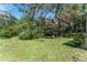 Lush green backyard with mature trees and a charming swing set, creating a serene outdoor space at 11307 Sandpine Rd, Riverview, FL 33569