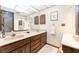 Bathroom featuring double sinks with granite counters, wood cabinets, and neutral-toned walls at 11307 Sandpine Rd, Riverview, FL 33569