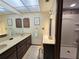 Bathroom with dual vanities, marble countertops, decorative mirrors, and a glass-enclosed shower at 11307 Sandpine Rd, Riverview, FL 33569