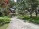 A long, winding driveway leads to a charming home surrounded by mature trees and lush landscaping at 11307 Sandpine Rd, Riverview, FL 33569