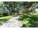 Long driveway leading to the home, framed by mature trees and lush landscaping, creating curb appeal at 11307 Sandpine Rd, Riverview, FL 33569