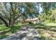 Exterior view of a home showcasing its long driveway and beautifully landscaped surroundings at 11307 Sandpine Rd, Riverview, FL 33569