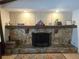 Stone fireplace with wood mantel, recessed lighting, and decorative accents create a cozy ambiance at 11307 Sandpine Rd, Riverview, FL 33569