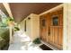 Inviting front porch with decorative wooden door and hanging plants for an inviting entrance to the residence at 11307 Sandpine Rd, Riverview, FL 33569