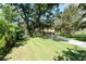Sprawling front yard of a single story home featuring mature trees offering substantial shade coverage at 11307 Sandpine Rd, Riverview, FL 33569