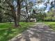 A long driveway shaded by mature trees leads to a charming house at 11307 Sandpine Rd, Riverview, FL 33569