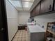 Well-lit laundry room has cabinets, washer, dryer and lots of storage at 11307 Sandpine Rd, Riverview, FL 33569