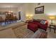 Comfortable living room with a red sofa, decorative pillows, and seamless access to the dining area at 11307 Sandpine Rd, Riverview, FL 33569