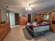 Spacious bedroom with warm wood furniture, ceiling fan, and neutral-colored tiled flooring at 11307 Sandpine Rd, Riverview, FL 33569