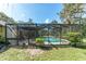Screened-in pool with clear water, surrounded by lush greenery and patio furniture at 11307 Sandpine Rd, Riverview, FL 33569