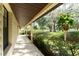 Exterior view of the covered front porch with hanging potted plants and lush landscaping at 11307 Sandpine Rd, Riverview, FL 33569