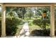 Charming porch view features a walkway to lush landscaping and mature trees on the property at 11307 Sandpine Rd, Riverview, FL 33569