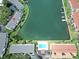 Aerial view showcases the complex, a large waterway, and a community swimming pool at 12132 Capri S Cir, Treasure Island, FL 33706