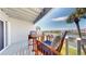Cozy balcony seating area with waterfront view and palm trees at 12132 Capri S Cir, Treasure Island, FL 33706